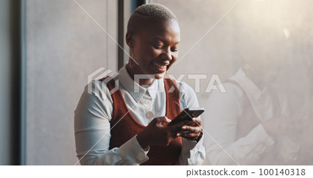 Happy, smile and face of a black woman on a phone while standing by the window in office. Technology, happiness and African female employee networking on social media or the internet on break at work Happy, smile and face of a black woman on a phone while standing by the window in office. Technology, happiness and African female employee networking on social media or the internet on break at work 100140318