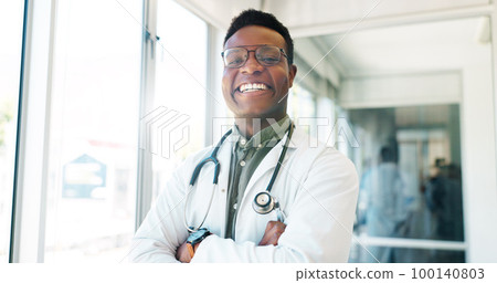 Portrait, healthcare and trust with a black man doctor standing arms crossed in a hospital hallway. Health, medical and insurance with a male medicine professional working in a clinic for treatment 100140803