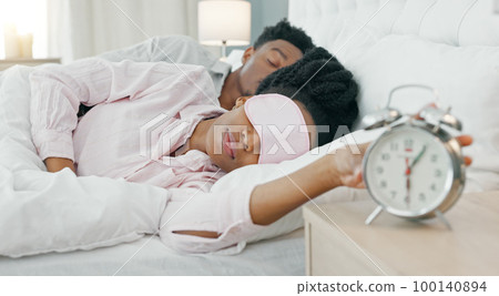 Black woman waking up in bed to switch off her alarm clock with a sleep mask in her house. Lazy, sleepy and African girl sleeping in her comfortable bedroom with an early morning get up time at home. Black woman waking up in bed to switch off her alarm clock with a sleep mask in her house. Lazy, sleepy and African girl sleeping in her comfortable bedroom with an early morning get up time at home. 100140894
