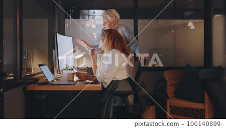 Office, overtime and woman with manager at computer, coaching for worker on online project for digital marketing company. Teamwork, advice and support from management for girl working late at night. 100140899