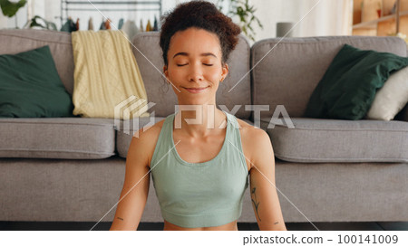 Gratitude, meditation and face of a woman with peace, mind freedom and happy with spiritual journey on floor. Yoga, zen and portrait of a girl with prayer hands during calm exercise in the lounge Gratitude, meditation and face of a woman with peace, mind freedom and happy with spiritual journey on floor. Yoga, zen and portrait of a girl with prayer hands during calm exercise in the lounge 100141009