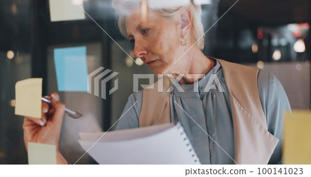Planning, CEO or woman writing on sticky note for development project or brainstorming creative ideas. Focus, data analysis or company manager working on marketing goals or branding strategy at night 100141023