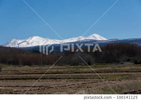 Paddy fields and snow-capped mountains on a sunny spring day Daisetsuzan Paddy fields and snow-capped mountains on a sunny spring day Daisetsuzan 100141125