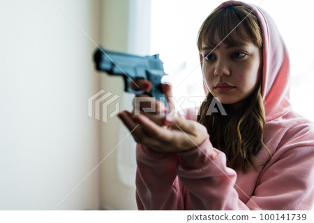 A scene like a movie of a woman holding a gun 100141739