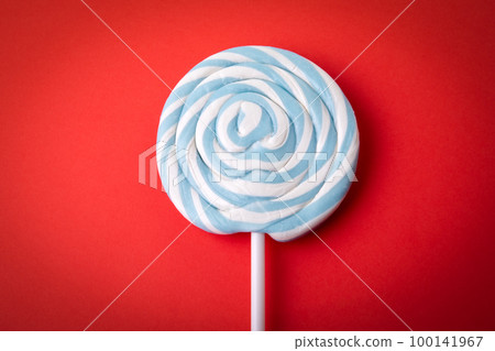 Blue candy on a stick, lollipop. Red background Blue candy on a stick, lollipop. Red background 100141967