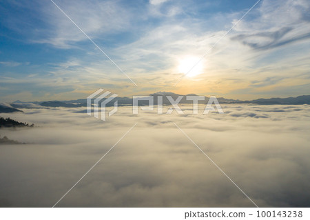 aerial view beautiful yellow sunrise above the mountain in phang Nga valley. slow floating fog blowing cover on the mountain look like as a sea of mist. scenery golden sunrise at horizon background. aerial view beautiful yellow sunrise above the mountain in phang Nga valley. slow floating fog blowing cover on the mountain look like as a sea of mist. scenery golden sunrise at horizon background. 100143238