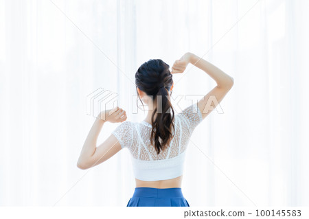 Rear view of a young woman in the morning sun Rear view of a young woman in the morning sun 100145583