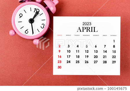 The April 2023 Monthly calendar year with alarm clock on red color background. The April 2023 Monthly calendar year with alarm clock on red color background. 100145675
