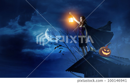 Beautiful young woman in witches hat and costume Beautiful young woman in witches hat and costume 100146941