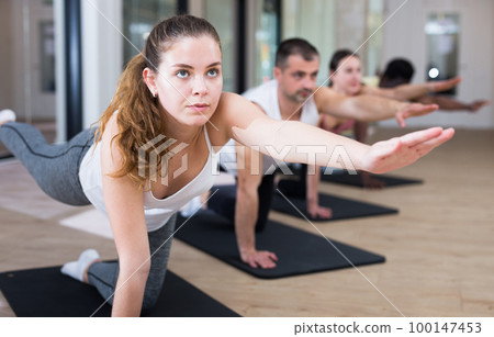 Woman practicing pilates exercises at group class Woman practicing pilates exercises at group class 100147453
