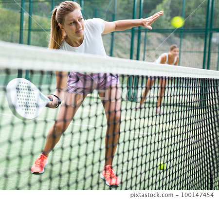 European woman padel tennis player trains on the outdoor court European woman padel tennis player trains on the outdoor court 100147454