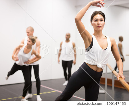 Woman practicing ballet elements in class 100147463