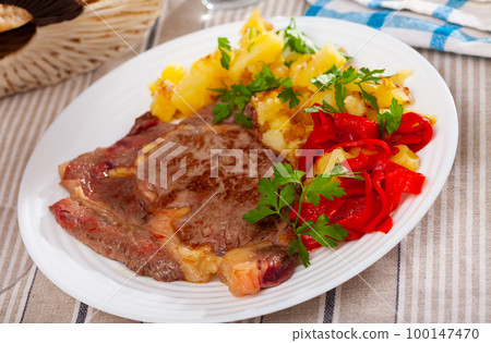 Veal steak with fried potatoes and pickled bell pepper Veal steak with fried potatoes and pickled bell pepper 100147470