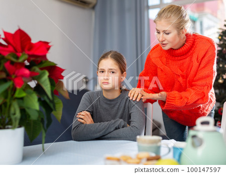 Mom soothes her teen daughter after a fight during Christmas holidays 100147597