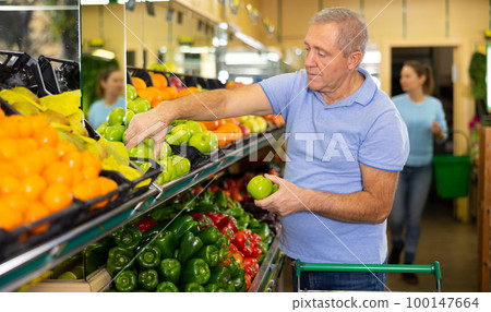 man buys apples in supermarket man buys apples in supermarket 100147664