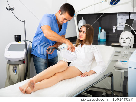 Glad woman receiving intense pulsed light (IPL) 100148057