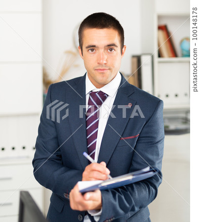 Portrait of positive business man with folder of documents 100148178