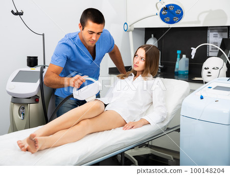 Positive male doing laser hair removal procedure Positive male doing laser hair removal procedure 100148204