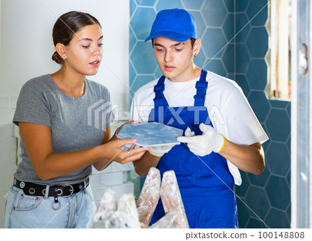 Young tile setter discusses works with a girl client Young tile setter discusses works with a girl client 100148808