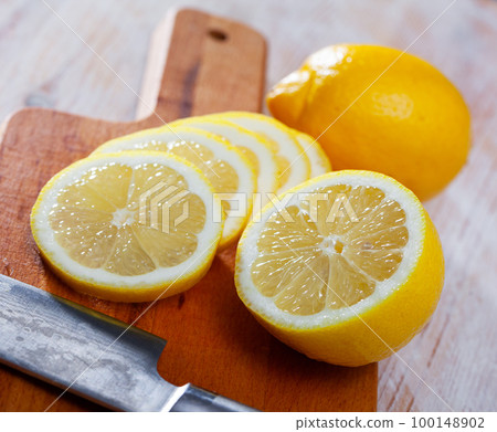 Sliced lemon on wooden table 100148902