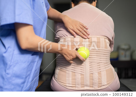 Physiotherapist massage back patient with ball at hospital,Physical therapy concept 100149312