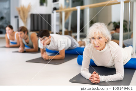 Group of different people doing exercises with roller Group of different people doing exercises with roller 100149461