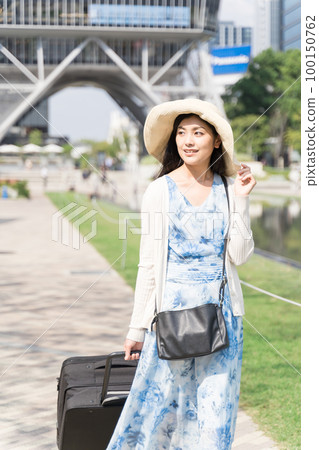一名年輕女子拉著行李箱在名古屋觀光 一名年輕女子拉著行李箱在名古屋觀光 100150762