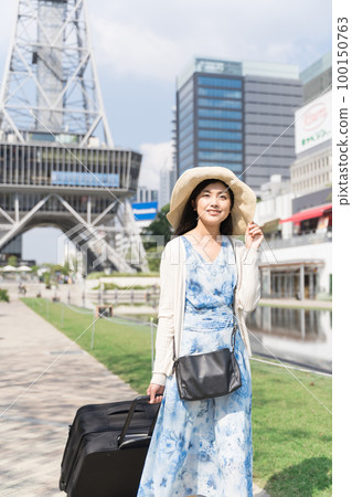 一名年輕女子拉著行李箱在名古屋觀光 一名年輕女子拉著行李箱在名古屋觀光 100150763