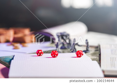 Role playing tabletop and board games begin fantasy and adventure background with book and miniature Role playing tabletop and board games begin fantasy and adventure background with book and miniature 100154644