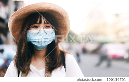Young asian cute traveller wear mask protect virus covid for new normal lifestyle. 100154701