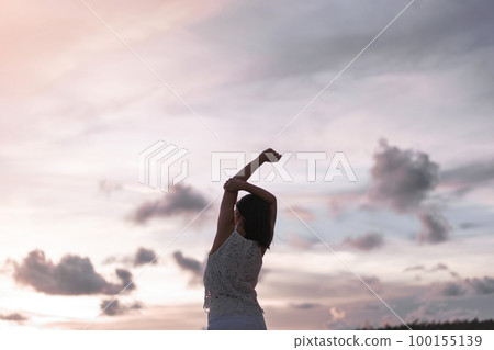 Rear view of young adult asian woman stretching hand and open arm relax on the beach. Rear view of young adult asian woman stretching hand and open arm relax on the beach. 100155139