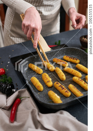 Mozzarella Cheese sticks are fried in oiled grill frying pan Mozzarella Cheese sticks are fried in oiled grill frying pan 100155535