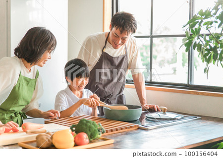 A couple, parent and child, family (tasting) who cooks and cooks with their children in the kitchen at home A couple, parent and child, family (tasting) who cooks and cooks with their children in the kitchen at home 100156404