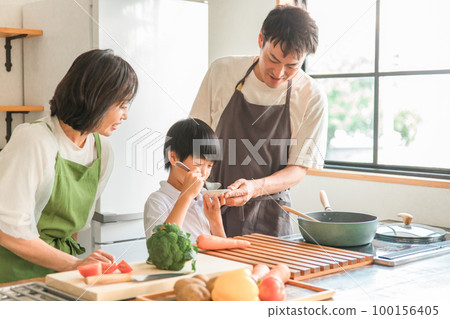 A couple, parent and child, family (tasting) who cooks and cooks with their children in the kitchen at home A couple, parent and child, family (tasting) who cooks and cooks with their children in the kitchen at home 100156405