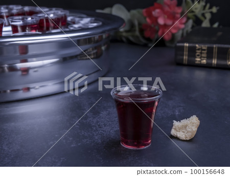 Taking communion concept - the wine and the bread symbols of Jesus Christ blood and body with Holy Bible 100156648