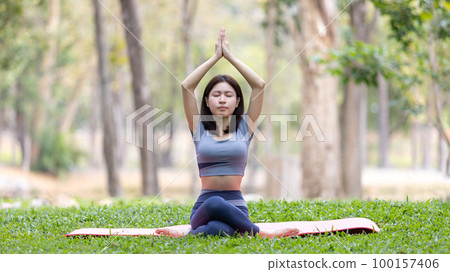 Asian woman doing yoga in nature in the forest, Meditation and breathing exercises, Treat ADHD and train your mind to be calm, Healthy exercise, Mindfulness, Homeopathy, Park yoga. Asian woman doing yoga in nature in the forest, Meditation and breathing exercises, Treat ADHD and train your mind to be calm, Healthy exercise, Mindfulness, Homeopathy, Park yoga. 100157406