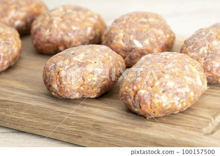 raw homemade meatballs on a massive board made of natural wood 100157500