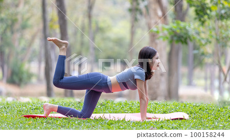 Asian woman doing yoga in nature in the forest, Meditation and breathing exercises, Treat ADHD and train your mind to be calm, Healthy exercise, Mindfulness, Homeopathy, Park yoga. Asian woman doing yoga in nature in the forest, Meditation and breathing exercises, Treat ADHD and train your mind to be calm, Healthy exercise, Mindfulness, Homeopathy, Park yoga. 100158244