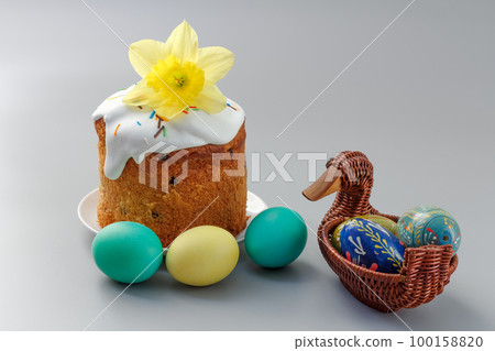 Easter cake and colorful Easter eggs in wicker basket. 100158820