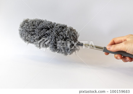 Dust collector brush gray in a woman's hand on a white background Dust collector brush gray in a woman's hand on a white background 100159683