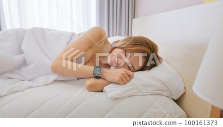 Woman sleeping with smart watch 100161373
