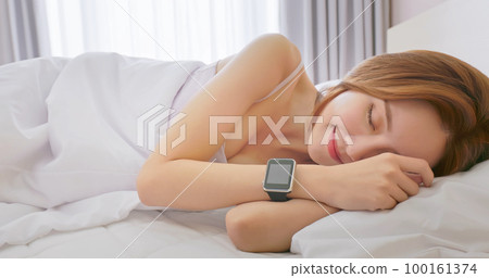 Woman sleeping with smart watch 100161374