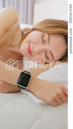 Woman sleeping with smart watch 100161440