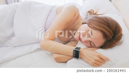 Woman sleeping with smart watch 100161441