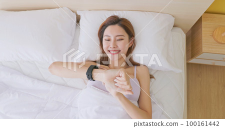 Woman wake up with smartwatch 100161442