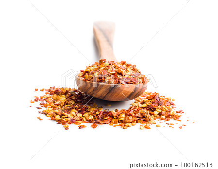 Dry chili pepper flakes in spoon. Crushed red peppers isolated on white background. 100162513