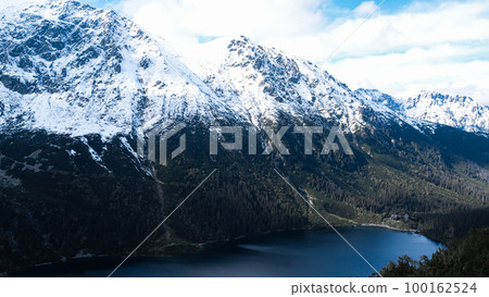 Czarny Staw pod Rysamy or Black Pond lake near the Morskie Oko Snowy Mountain Hut in Polish Tatry mountains, drone view, Zakopane, Poland. 4k Aerial view shot of beautiful green hills and mountains in 100162524