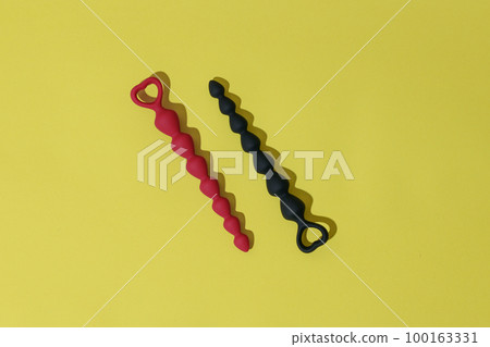 Anal plugs or dildo on yellow background with shadows. Sex shop concept. Sex toys for anal play 100163331
