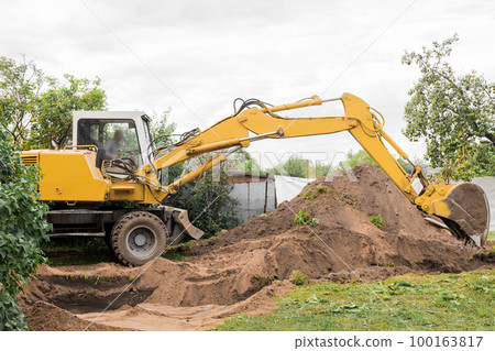 A excavator is digging on outdoors in an industrial site. Excavation works A excavator is digging on outdoors in an industrial site. Excavation works 100163817