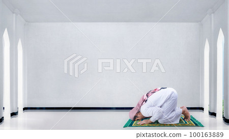 Muslim man with keffiyeh and agal in praying position (salat) 100163889